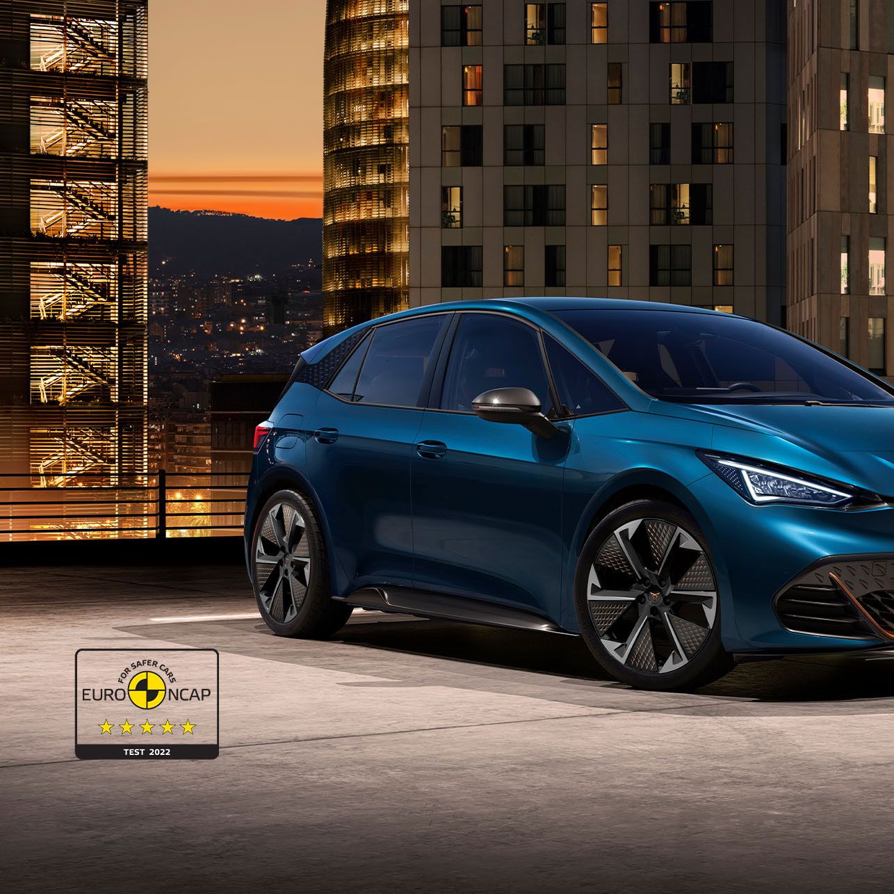 CUPRA Born kivilágított épületek előtt