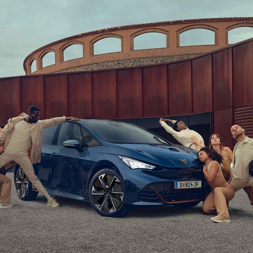 CUPRA Born mellett testszínű ruhában modellek pózolnak