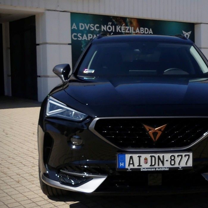 cupra modell mellett egy piros felsős fiatal lány áll