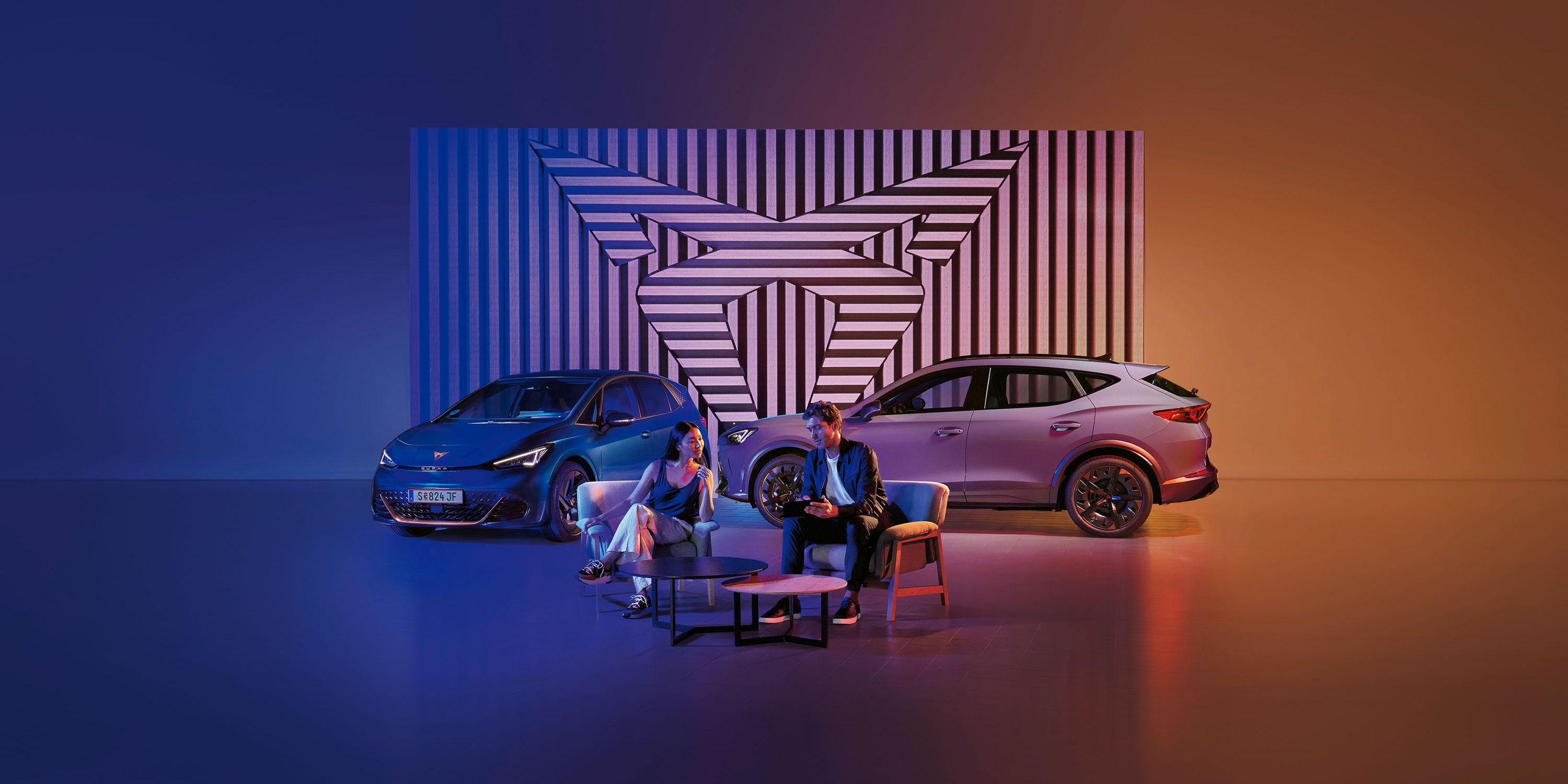 Zwei CUPRA Modelle-ein Mann und eine Frau sitzen davor