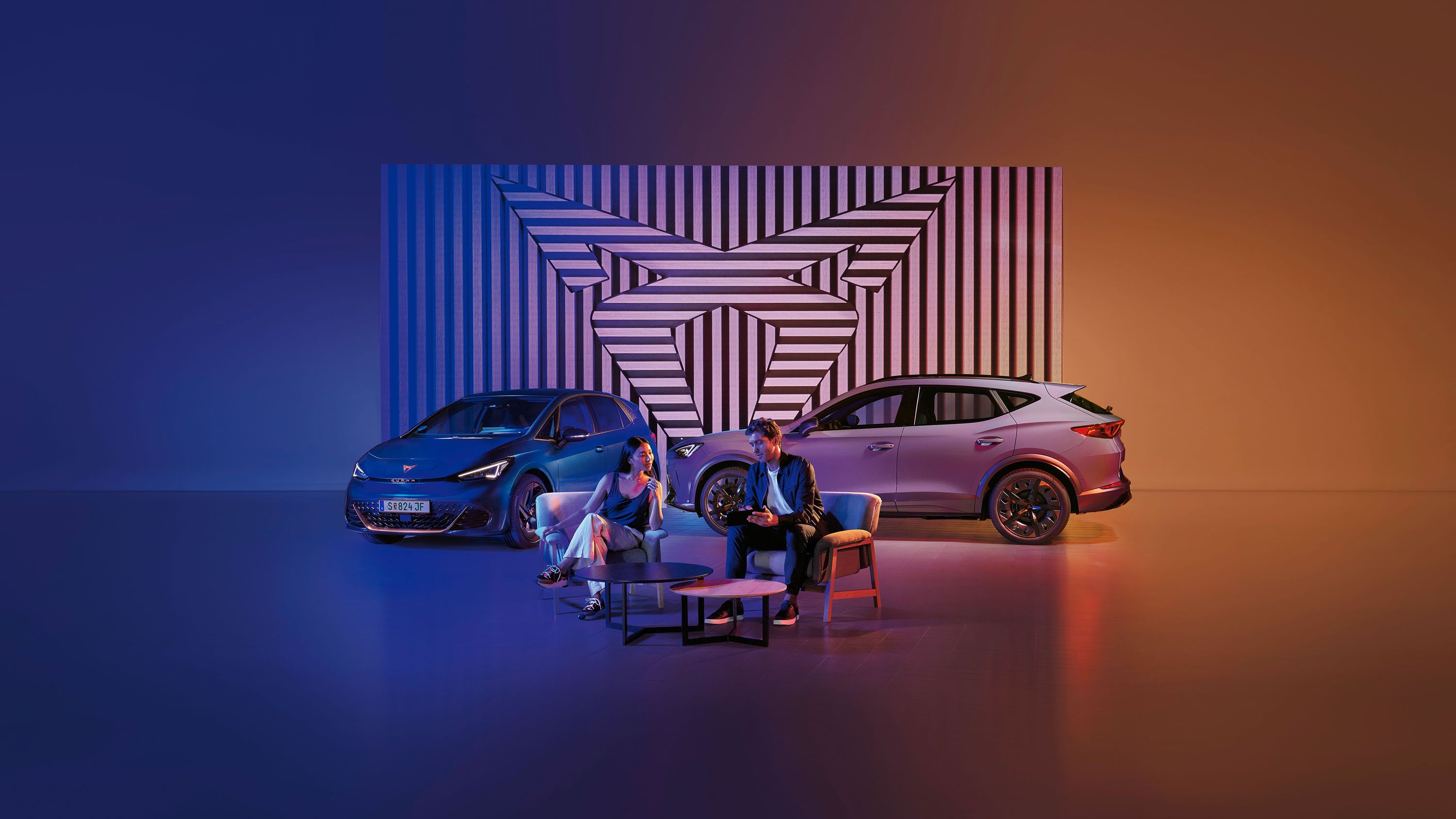 Zwei CUPRA Modelle-ein Mann und eine Frau sitzen davor
