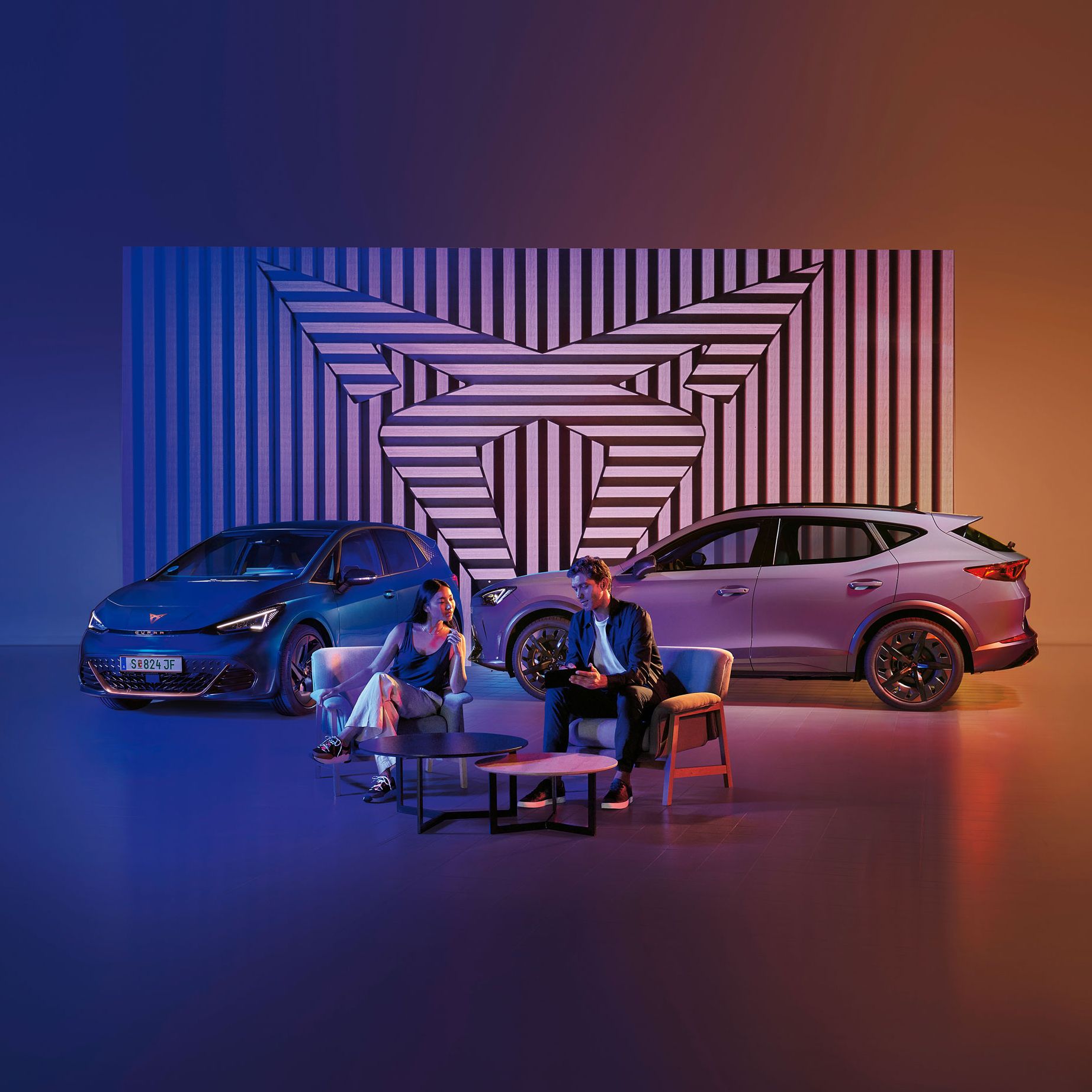 Zwei CUPRA Modelle-ein Mann und eine Frau sitzen davor