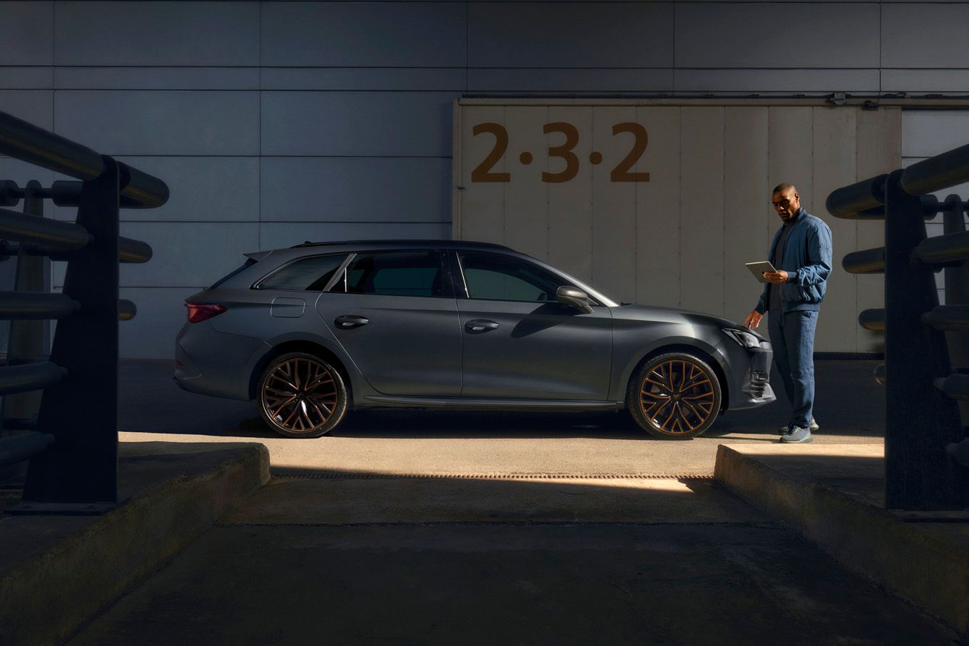 Ein Cupra Techniker mit Tablet neben einem CUPRA Leon SP Kombi.