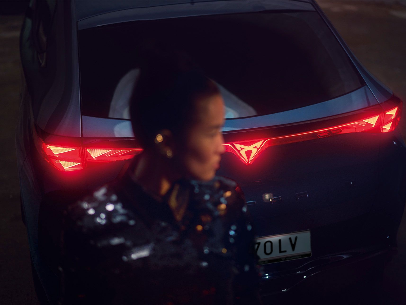 CUPRA Tavascan fényei és egy homályos női alak