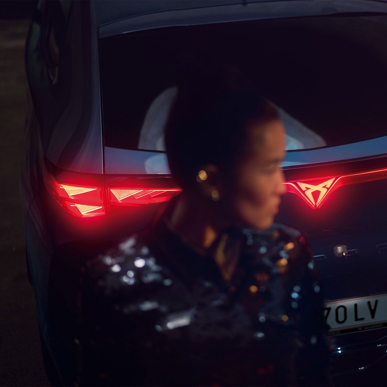 CUPRA Tavascan fényei és egy homályos női alak