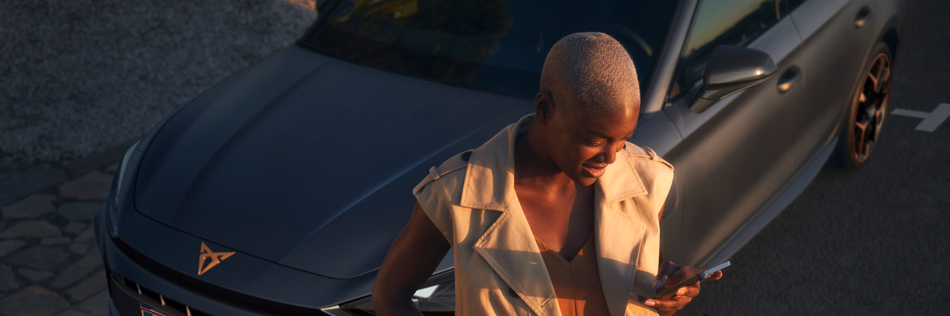 CUPRA modell mellett áll egy nő 