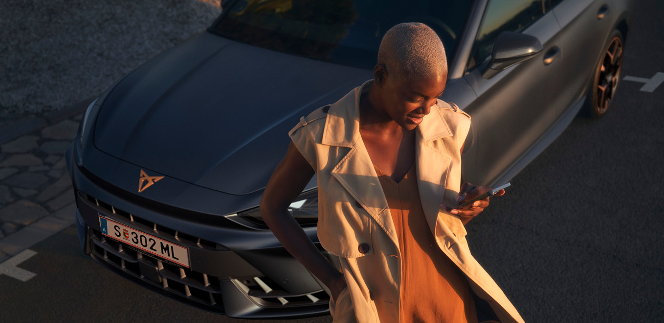 CUPRA modell mellett áll egy nő 