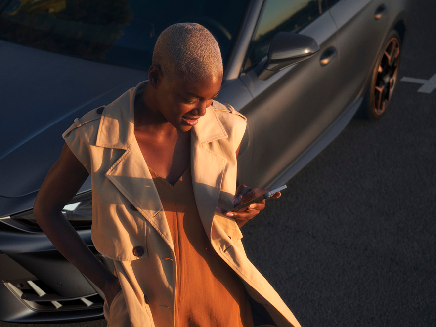 CUPRA modell mellett áll egy nő 